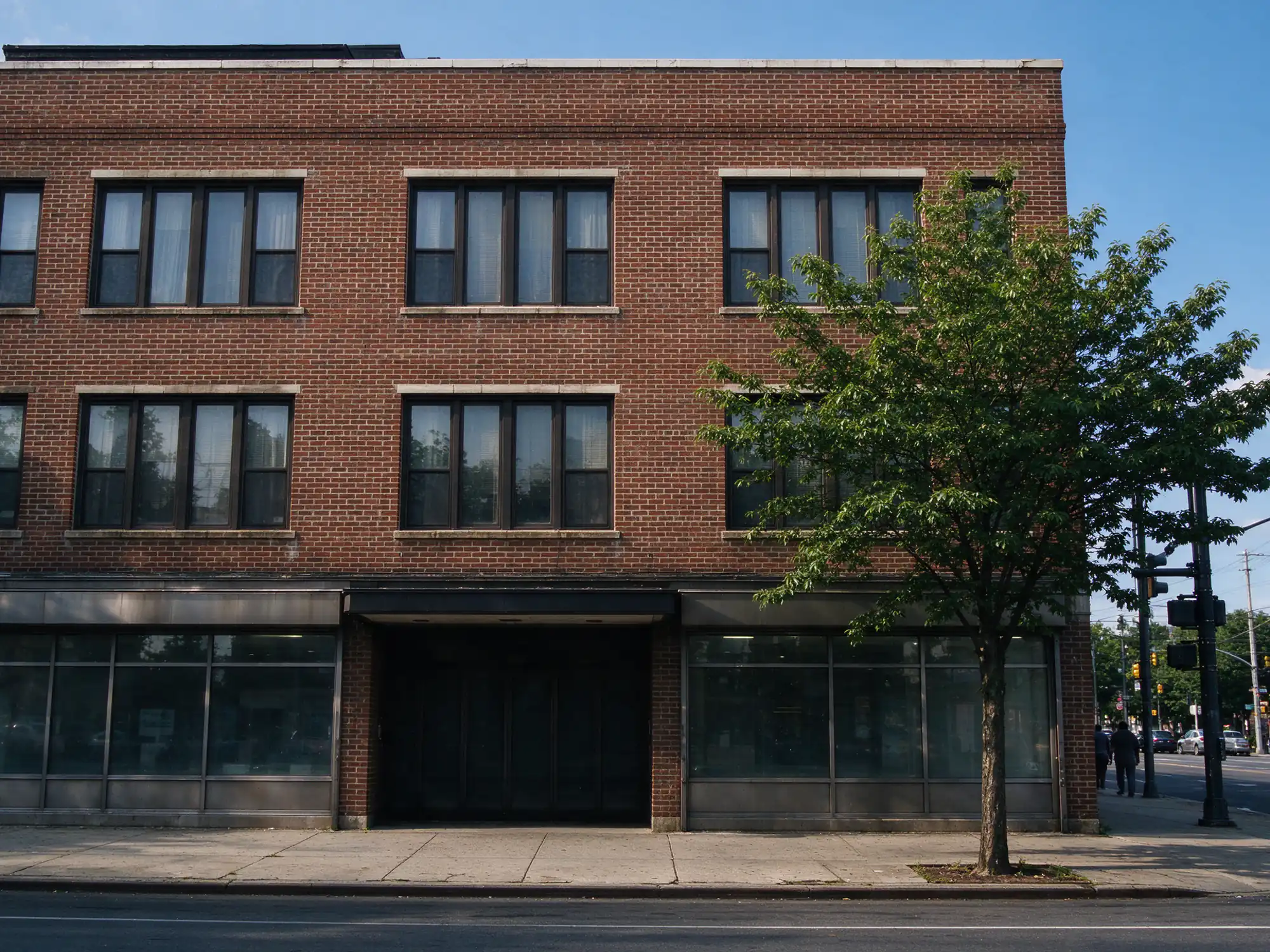 Brick walk-up apartment building with storefronts and a parapet on an avenue in Orange, NJ